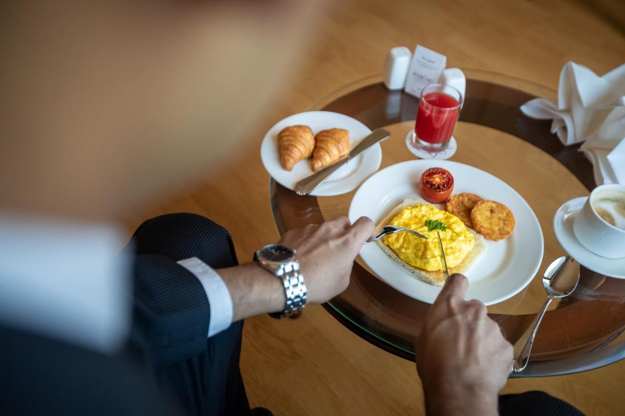 The Orchid Hotel Mumbai Vile Parle מראה חיצוני תמונה A man eating breakfast